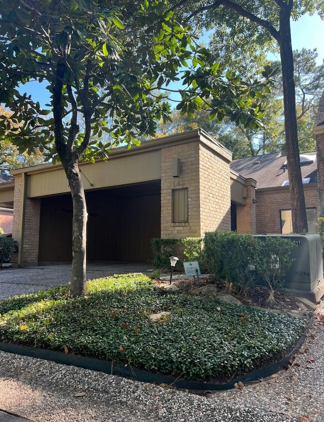 148 Sugarberry Cir, Houston, TX 77024 - view of side of home with brick siding, an attached garage, and driveway
