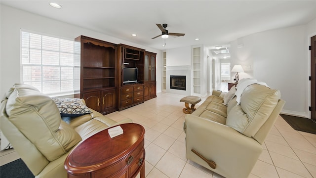 living room featuring ceiling fan, built in features, light tile patterned floors, recessed lighting, and a fireplace