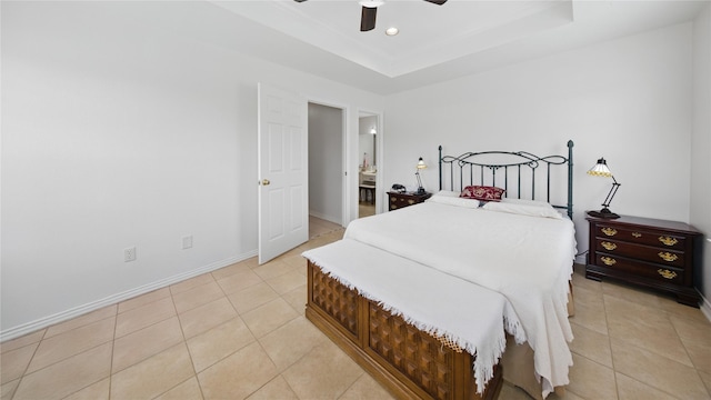 bedroom featuring light tile patterned floors, a ceiling fan, a raised ceiling, and baseboards