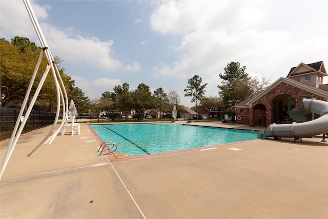 pool with a patio area and a water slide