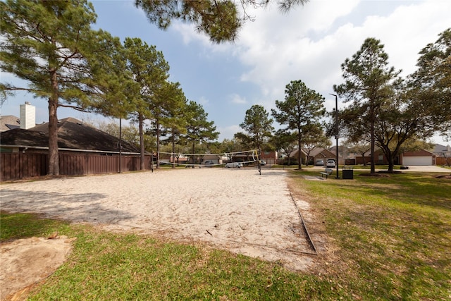 view of property's community with a yard, volleyball court, and fence