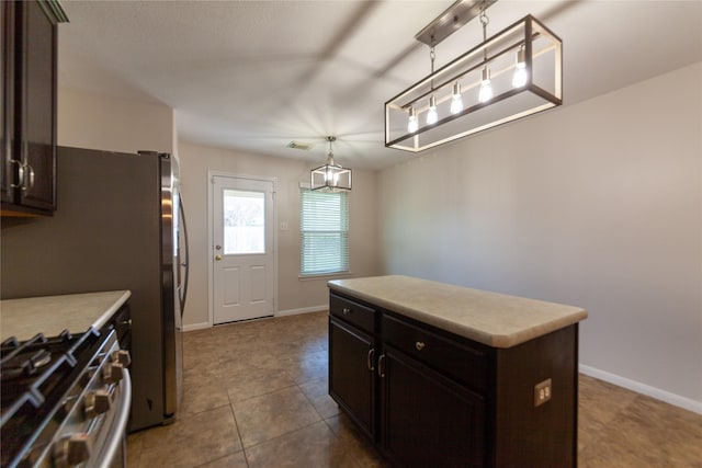 kitchen featuring stainless steel gas stove, dark brown cabinets, a kitchen island, and light countertops