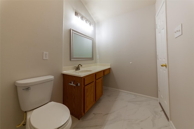 bathroom with baseboards, toilet, lofted ceiling, marble finish floor, and vanity