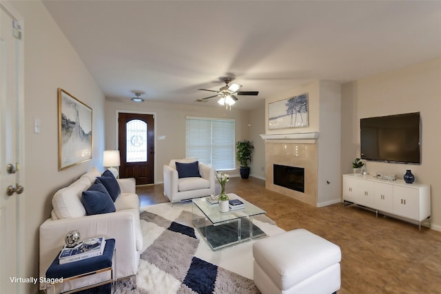 living room featuring a fireplace, baseboards, and a ceiling fan