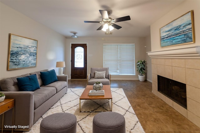 living room featuring baseboards, a ceiling fan, and a tile fireplace