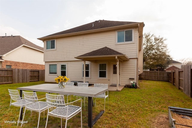 back of property with a patio area, a lawn, and a fenced backyard