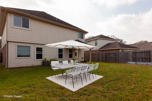 rear view of property featuring a yard, a patio, and fence