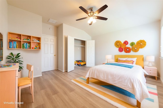 bedroom with light wood-type flooring, a closet, lofted ceiling, and baseboards