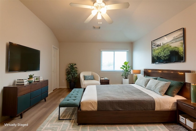 bedroom featuring light wood finished floors, visible vents, baseboards, lofted ceiling, and a ceiling fan