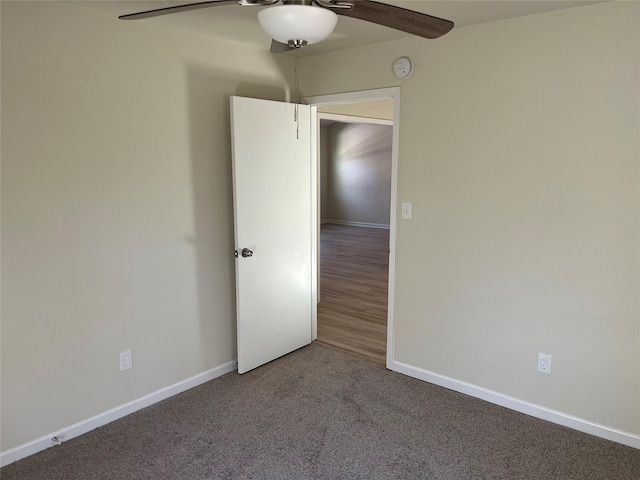 carpeted empty room featuring baseboards and ceiling fan