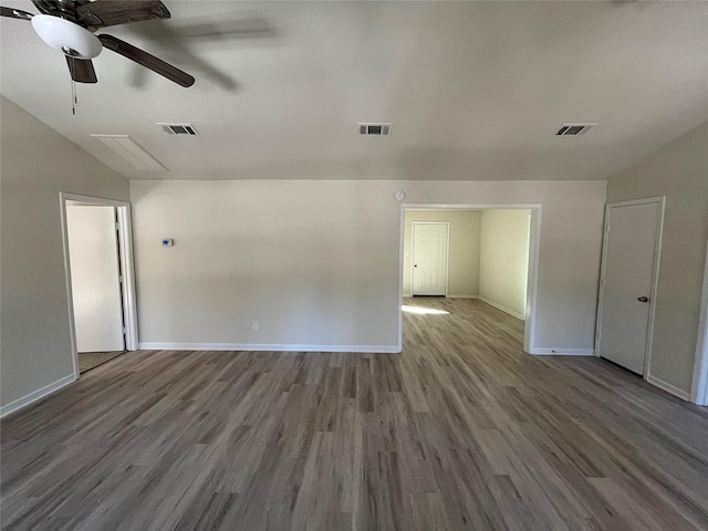 empty room featuring visible vents, a ceiling fan, and wood finished floors