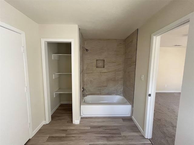 full bath with baseboards, shower / washtub combination, and wood finished floors