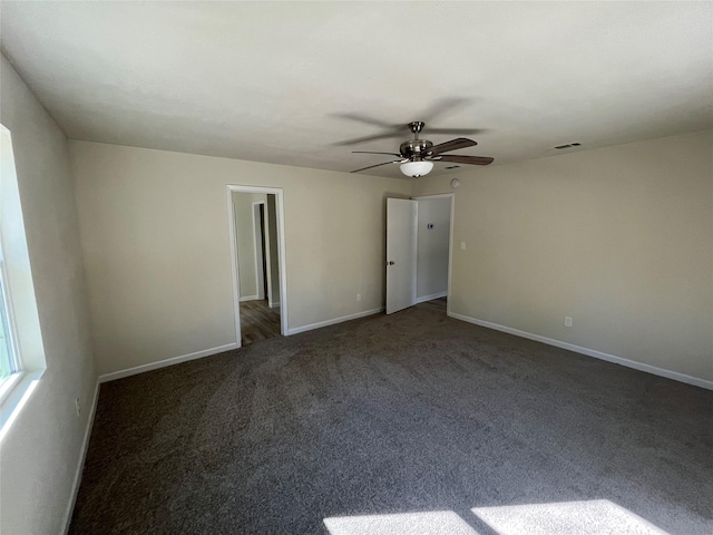 carpeted spare room featuring a ceiling fan, visible vents, and baseboards