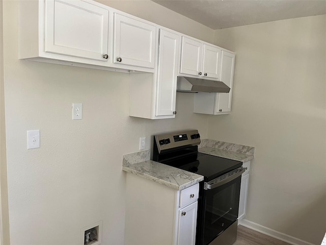 kitchen with under cabinet range hood, light stone counters, white cabinetry, stainless steel range with electric cooktop, and baseboards