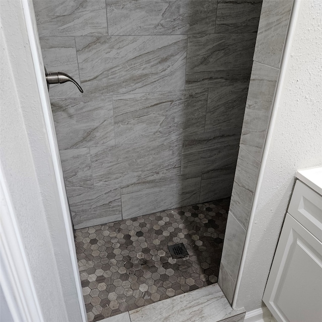 bathroom featuring a tile shower and vanity