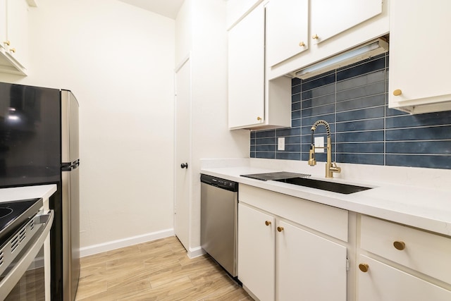 kitchen featuring decorative backsplash, light countertops, appliances with stainless steel finishes, and a sink