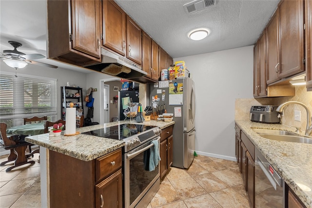 kitchen featuring visible vents, a sink, a peninsula, appliances with stainless steel finishes, and ceiling fan