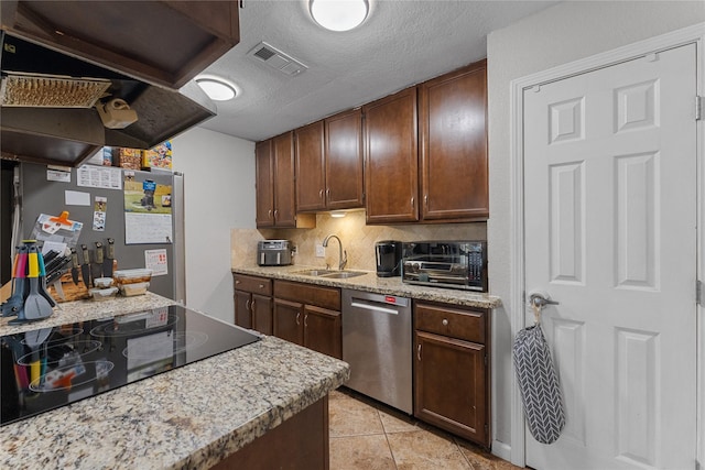 kitchen featuring visible vents, a sink, backsplash, stainless steel appliances, and light tile patterned floors