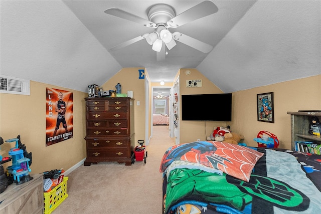 carpeted bedroom with vaulted ceiling, a ceiling fan, visible vents, and a textured ceiling