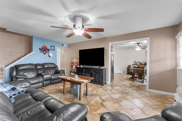 living room with visible vents, baseboards, and ceiling fan