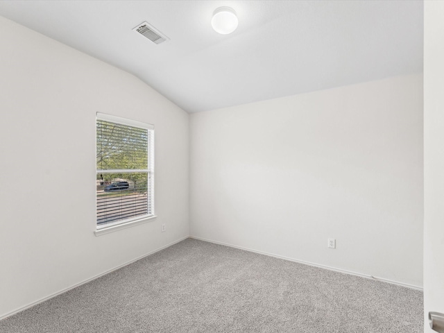 unfurnished room with visible vents, carpet flooring, baseboards, and lofted ceiling