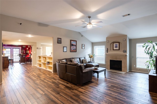 living area with a fireplace, a ceiling fan, visible vents, and dark wood-style flooring