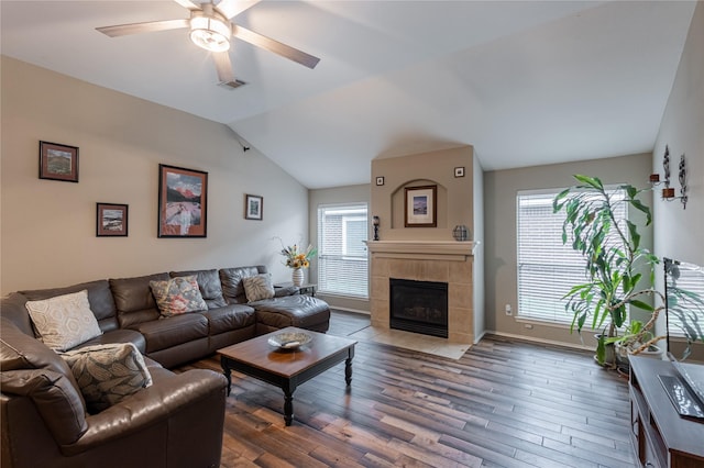 living area with visible vents, ceiling fan, lofted ceiling, and wood finished floors