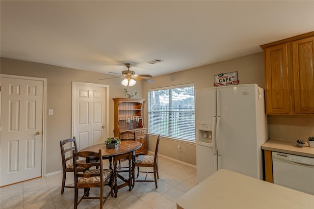 dining space featuring light tile patterned flooring, a ceiling fan, visible vents, and baseboards