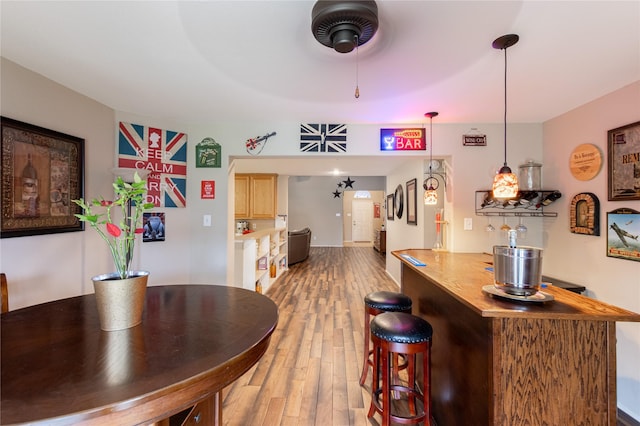 bar with decorative light fixtures and wood finished floors