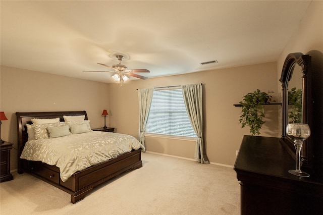 bedroom featuring visible vents, baseboards, light colored carpet, and a ceiling fan