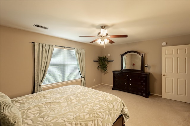 bedroom featuring visible vents, light colored carpet, baseboards, and ceiling fan