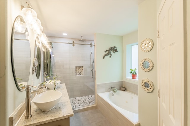 bathroom featuring tile patterned floors, a stall shower, a sink, a jetted tub, and double vanity