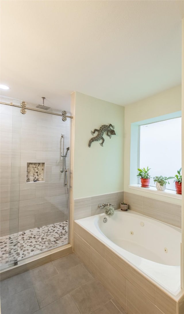 full bath featuring a whirlpool tub, a shower stall, and tile patterned flooring