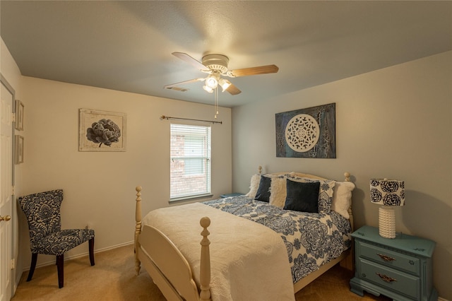 carpeted bedroom featuring visible vents, baseboards, and a ceiling fan