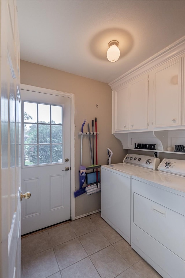 laundry room featuring light tile patterned floors, cabinet space, and washer and dryer