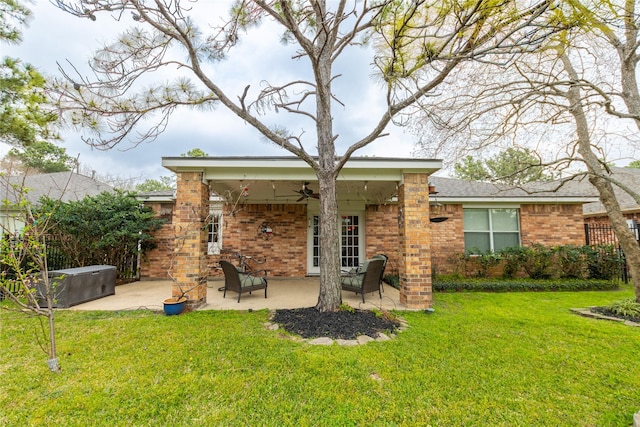 rear view of property with a patio, a lawn, ceiling fan, and brick siding