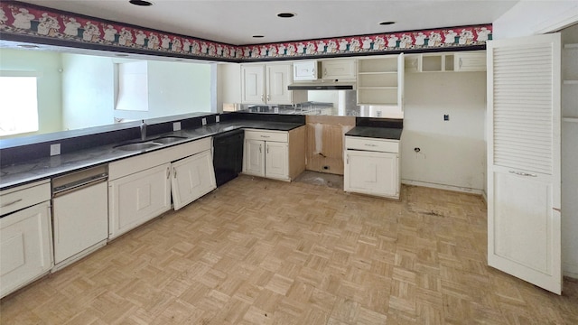 kitchen with a sink, dark countertops, dishwasher, and white cabinets