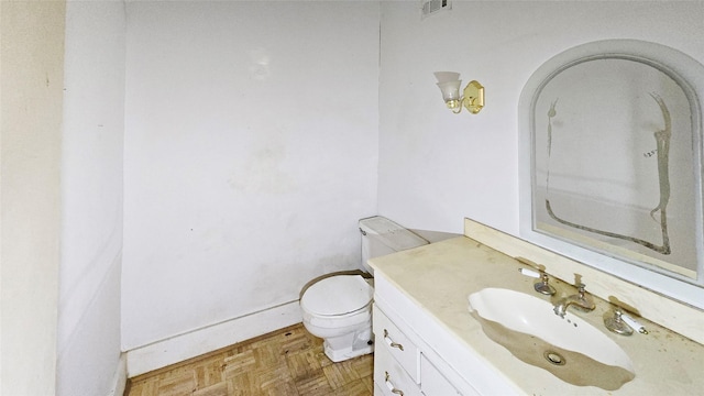 bathroom featuring visible vents, toilet, and vanity