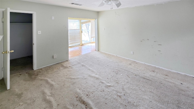 unfurnished bedroom with a ceiling fan, visible vents, baseboards, a spacious closet, and carpet flooring