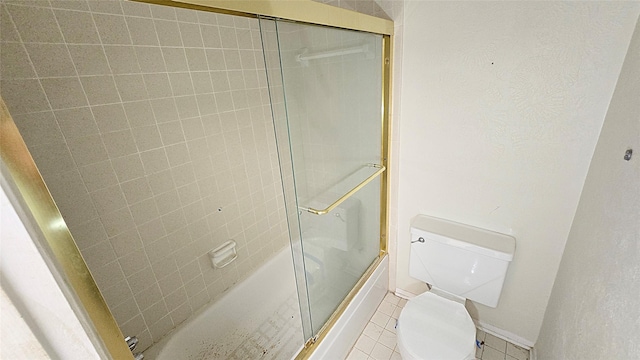 full bath featuring tile patterned floors, toilet, and bath / shower combo with glass door