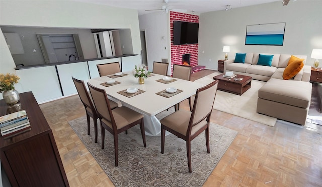 dining area with a ceiling fan and a fireplace