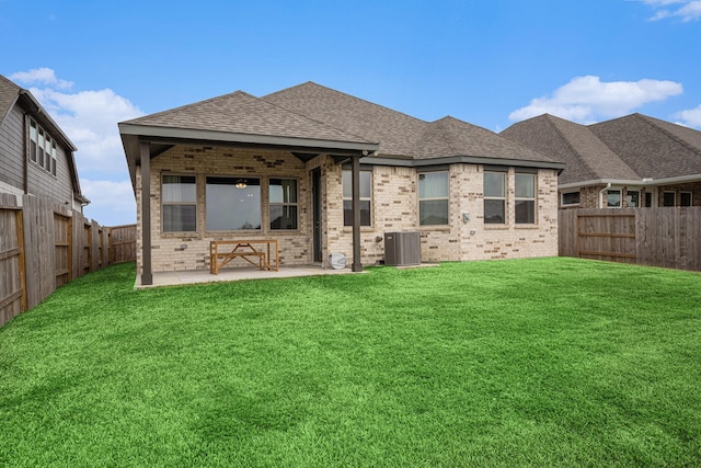 rear view of property with brick siding, a fenced backyard, a lawn, and a shingled roof