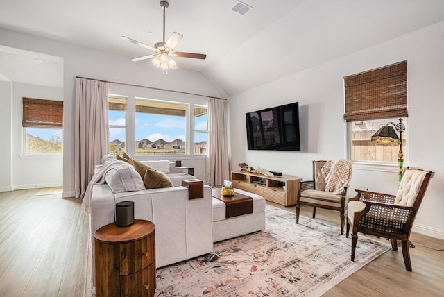 living room featuring visible vents, light wood-style floors, a healthy amount of sunlight, and ceiling fan