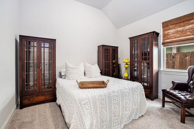 bedroom featuring baseboards, light carpet, french doors, and vaulted ceiling