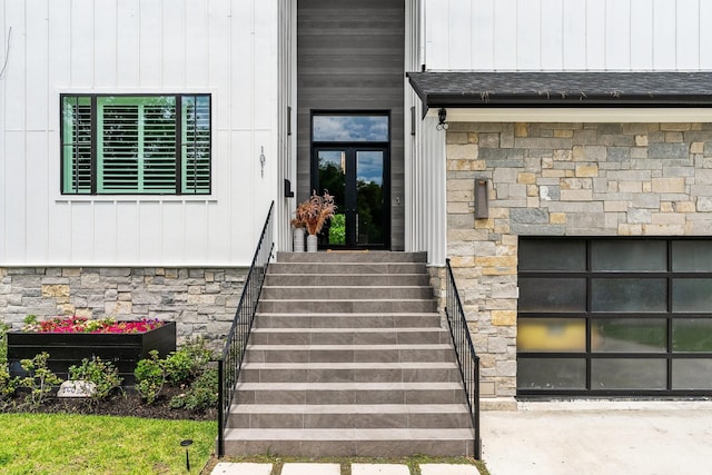 property entrance featuring a garage, stone siding, and roof with shingles