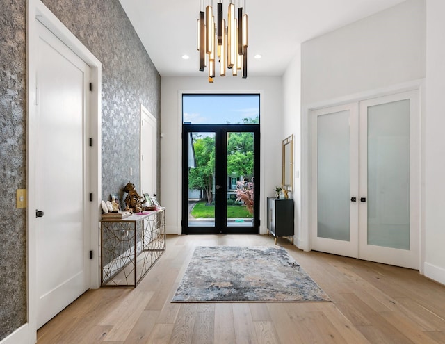 entryway featuring hardwood / wood-style floors, recessed lighting, french doors, and wallpapered walls