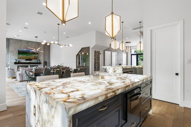 kitchen with light wood-style flooring, a notable chandelier, and recessed lighting