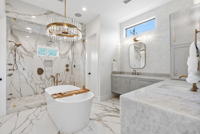 full bath with marble finish floor, a marble finish shower, a soaking tub, a chandelier, and vanity