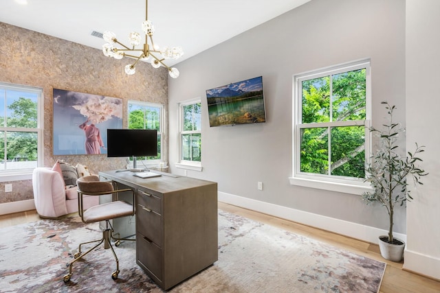 office area featuring an inviting chandelier, light wood-style flooring, visible vents, and baseboards