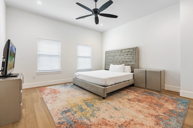 bedroom featuring light wood finished floors, recessed lighting, and baseboards